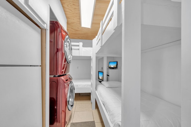 interior space with laundry area, light tile patterned floors, and stacked washer / drying machine