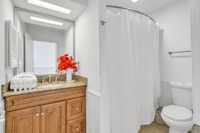 full bathroom featuring toilet, a wainscoted wall, vanity, tile patterned floors, and a shower with shower curtain