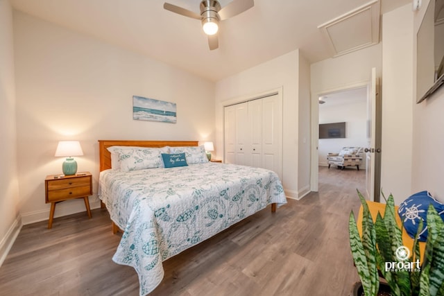 bedroom featuring baseboards, a closet, attic access, and wood finished floors