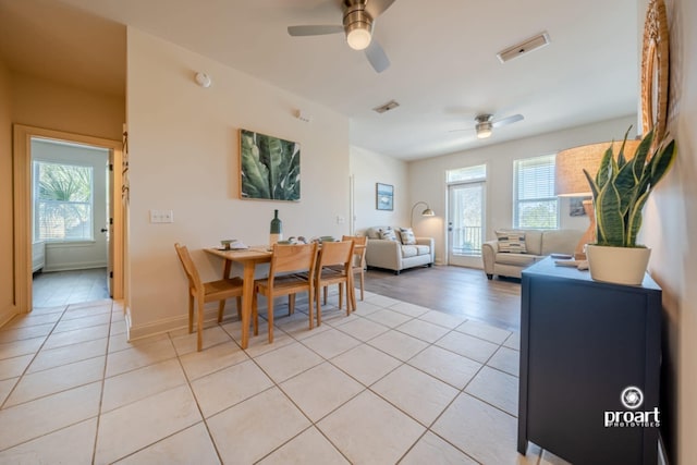 dining room with light tile patterned floors, ceiling fan, visible vents, and a healthy amount of sunlight