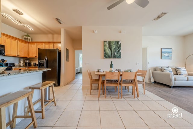 dining area featuring visible vents, ceiling fan, and light tile patterned floors