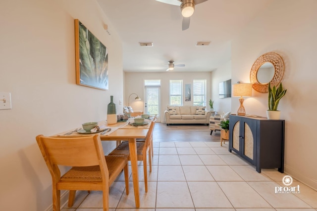 dining area featuring baseboards, ceiling fan, visible vents, and light tile patterned floors