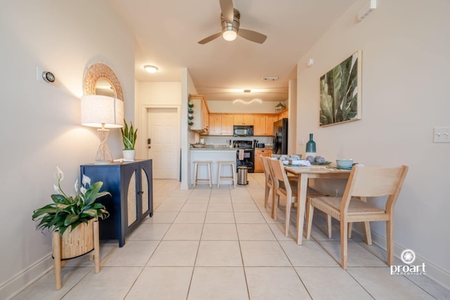 dining room featuring a ceiling fan, baseboards, and light tile patterned floors