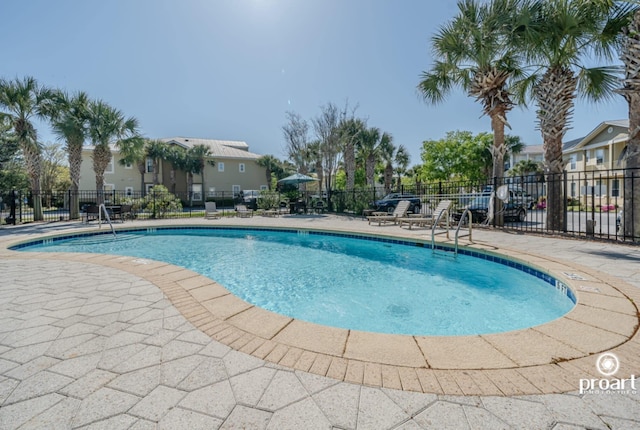 community pool with fence and a patio
