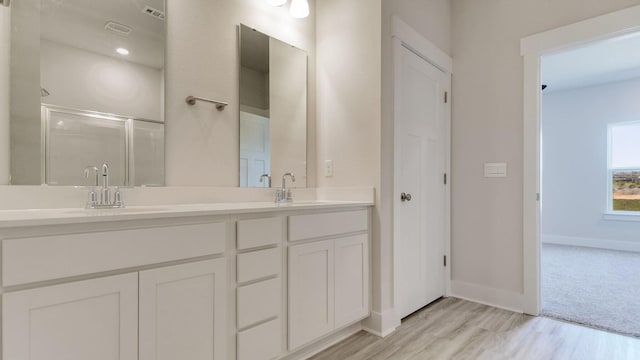 3068 Heritage Plantation Blvd, Laurel Hill, FL 32567 - bathroom featuring a sink, double vanity, baseboards, a shower stall, and wood finished floors
