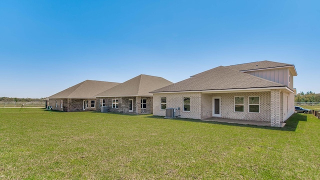 3068 Heritage Plantation Blvd, Laurel Hill, FL 32567 - back of property featuring roof with shingles, central AC, brick siding, board and batten siding, and a lawn
