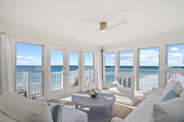 sunroom featuring french doors, a water view, and a wealth of natural light