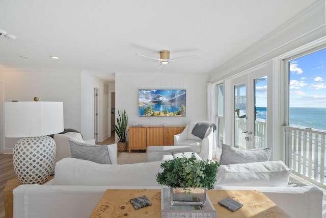 living room featuring ceiling fan, ornamental molding, and wood finished floors