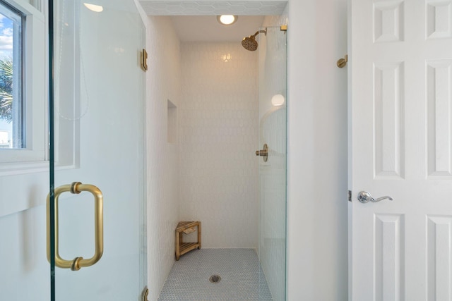 bathroom featuring a healthy amount of sunlight, tile patterned flooring, and a stall shower