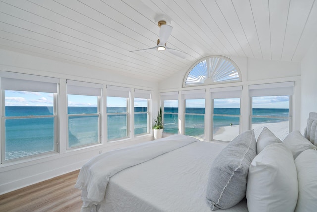 bedroom with a water view, multiple windows, vaulted ceiling, and wooden ceiling