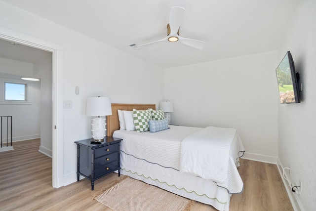 bedroom featuring baseboards, ceiling fan, and wood finished floors