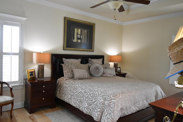 bedroom with baseboards, multiple windows, ornamental molding, and wood finished floors