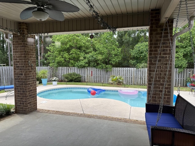 view of swimming pool featuring a patio, a ceiling fan, and a fenced backyard