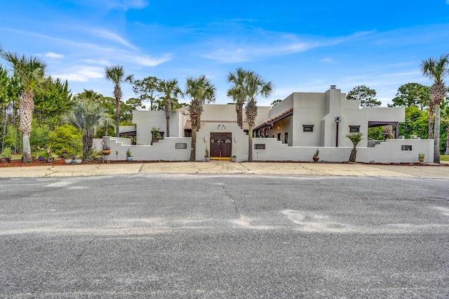 35 Blue Bayou Dr, Santa Rosa Beach, FL 32459 - view of front facade with stucco siding, a fenced front yard, and a gate