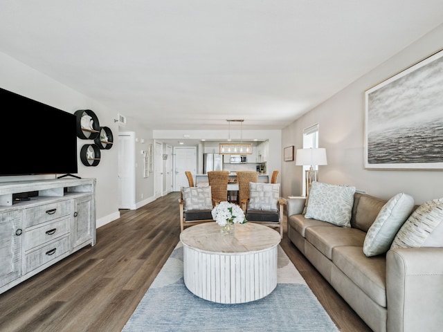 living area with dark wood-type flooring and baseboards