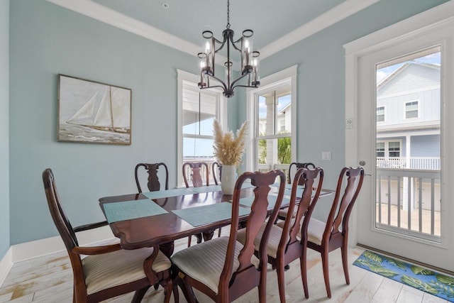 dining room featuring a chandelier, light wood-style floors, and baseboards
