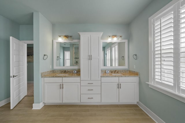 full bath featuring wood finished floors, baseboards, and vanity