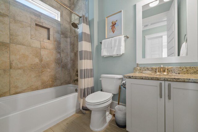 full bathroom with toilet, shower / tub combo with curtain, vanity, wood finished floors, and baseboards