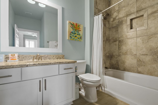 full bath with wood finished floors, toilet, vanity, and shower / bath combo