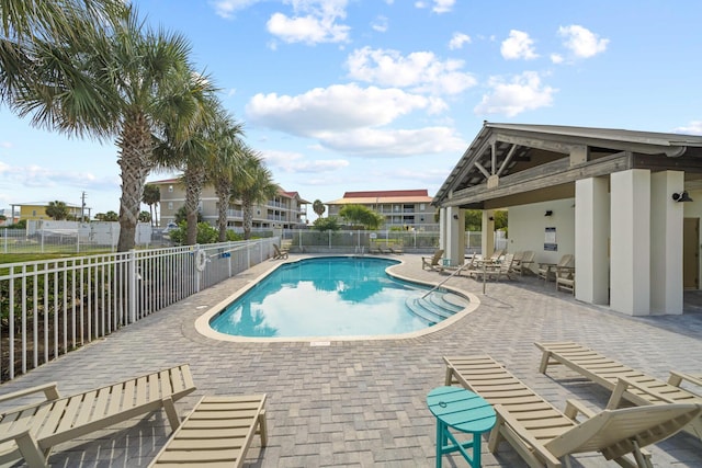 community pool featuring fence and a patio