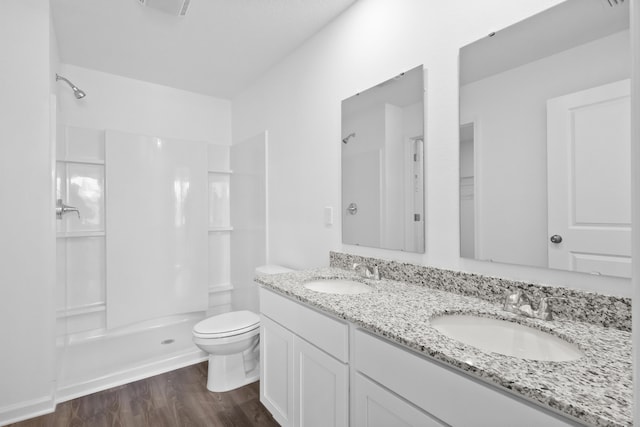 bathroom featuring a sink, walk in shower, and wood finished floors
