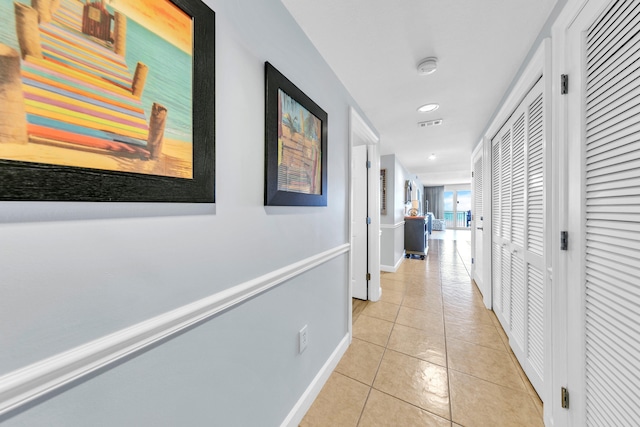 corridor with light tile patterned floors, visible vents, baseboards, and recessed lighting