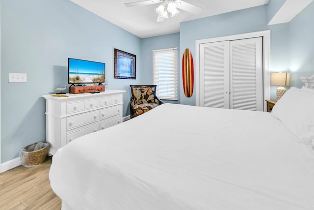 bedroom with baseboards, light wood-style floors, a closet, and ceiling fan