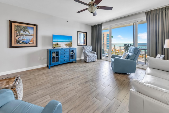 living room with wood finished floors, baseboards, and a ceiling fan