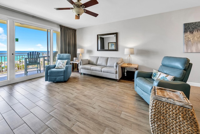 living room with a water view, light wood finished floors, and ceiling fan