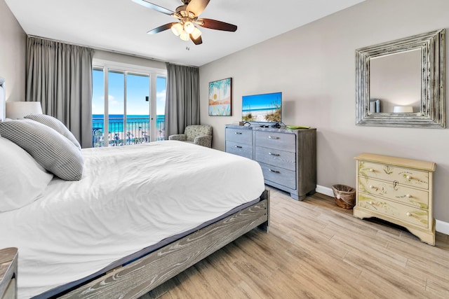 bedroom with light wood-style floors, baseboards, a ceiling fan, and access to exterior