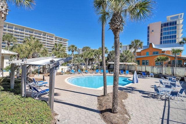 community pool featuring a patio, a pergola, and fence