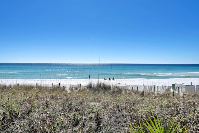 view of water feature with a beach view and fence