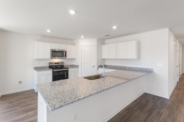 kitchen with a sink, dark wood finished floors, appliances with stainless steel finishes, and white cabinets