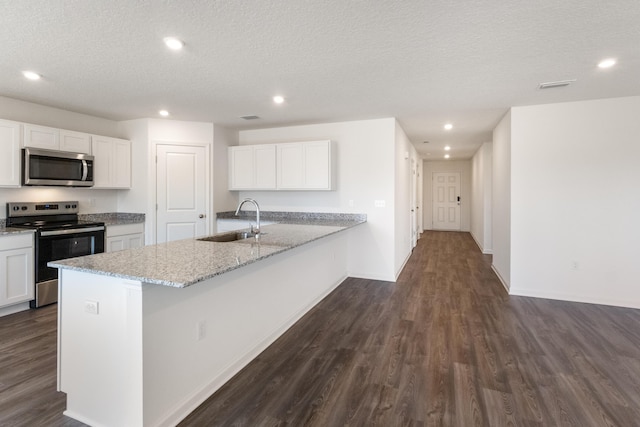 kitchen featuring a sink, dark wood finished floors, appliances with stainless steel finishes, and white cabinets