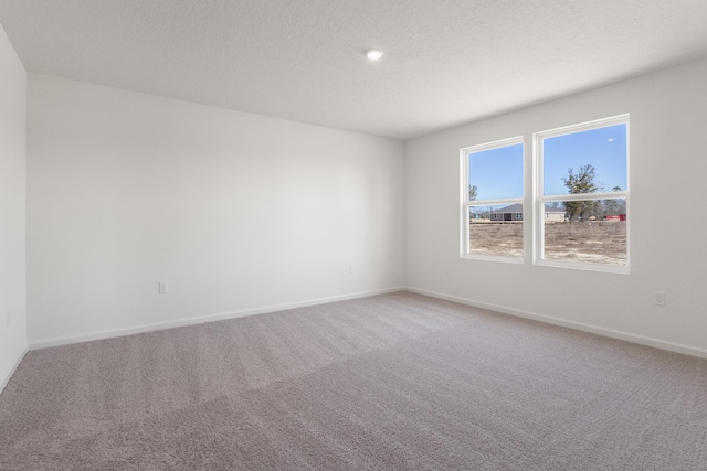 spare room with light colored carpet and baseboards