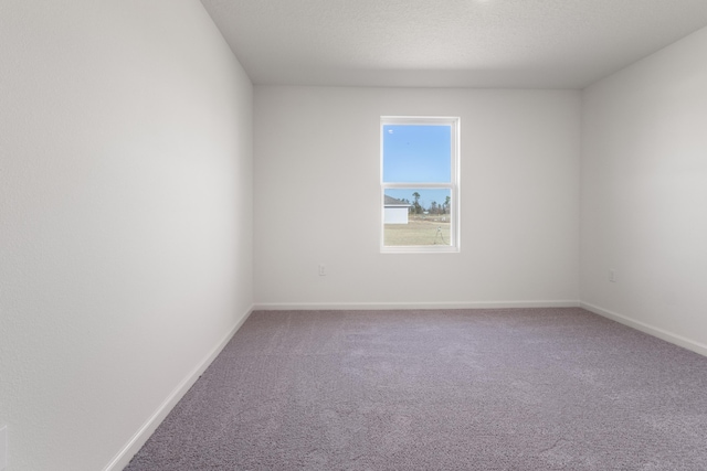 carpeted empty room with baseboards