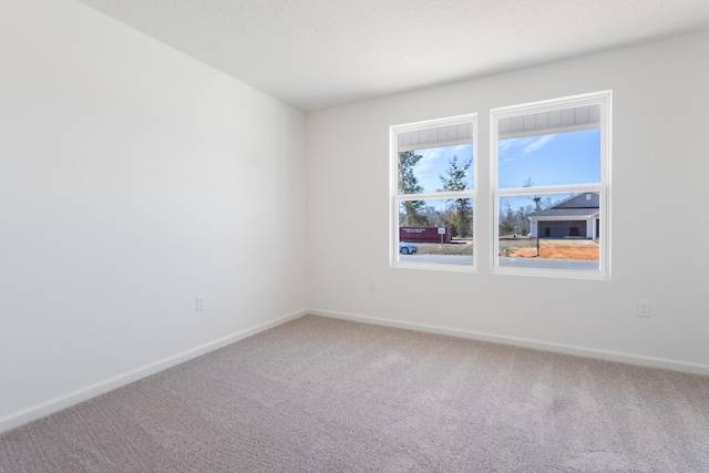 carpeted empty room with baseboards
