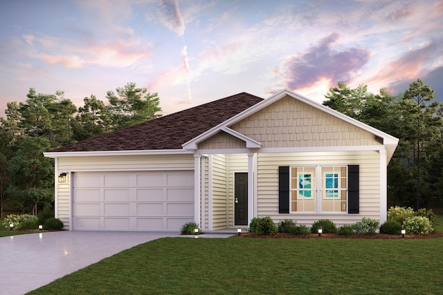 view of front facade featuring an attached garage, driveway, and a front yard