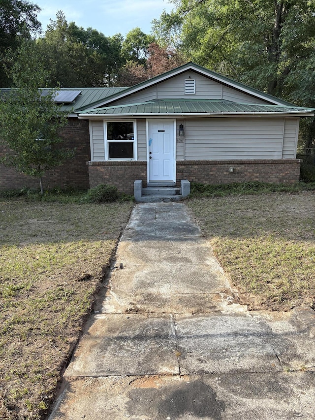 404 W 1st Ave, Crestview, FL 32536 - view of front facade featuring brick siding and metal roof
