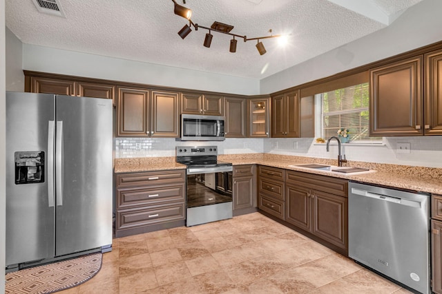 960 Valley Rd, Crestview, FL 32539 - kitchen with visible vents, light stone countertops, a textured ceiling, a sink, and stainless steel appliances