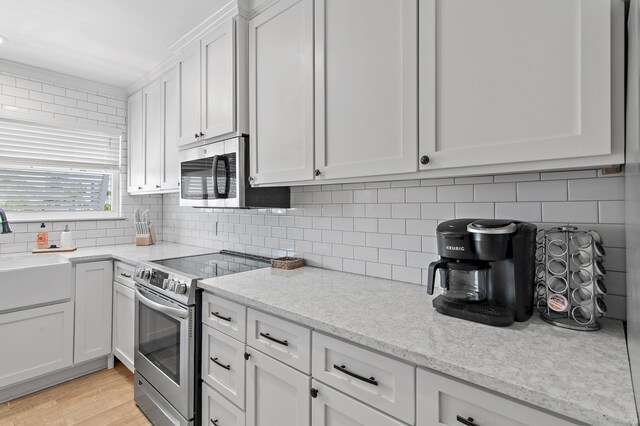 169 Durango Rd, Destin, FL 32541 - kitchen featuring a sink, white cabinets, stainless steel appliances, and tasteful backsplash