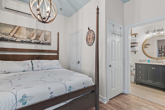 10343 E County Highway 30a Unit B233, Rosemary Beach, FL 32461 - bedroom featuring an AC wall unit, a sink, a chandelier, connected bathroom, and light wood-style floors