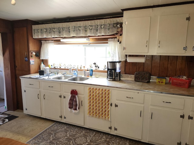 258 Briar Rd, Defuniak Springs, FL 32433 - kitchen with a sink, white cabinets, light countertops, and wood walls