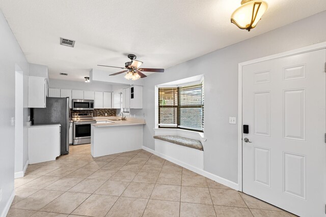 kitchen featuring white cabinets, ceiling fan, appliances with stainless steel finishes, a sink, and visible vents