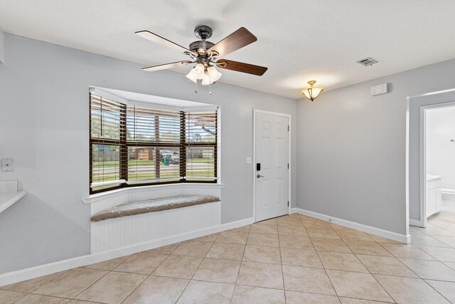 foyer entrance featuring light tile patterned floors, baseboards, ceiling fan, and visible vents