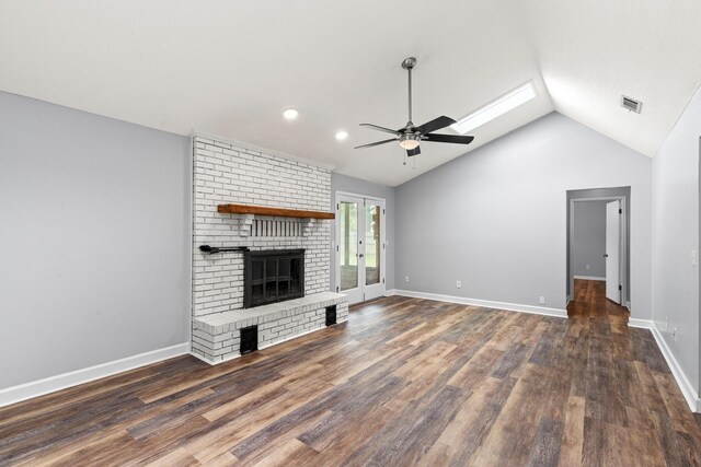 unfurnished living room featuring a brick fireplace, a ceiling fan, wood finished floors, vaulted ceiling, and visible vents