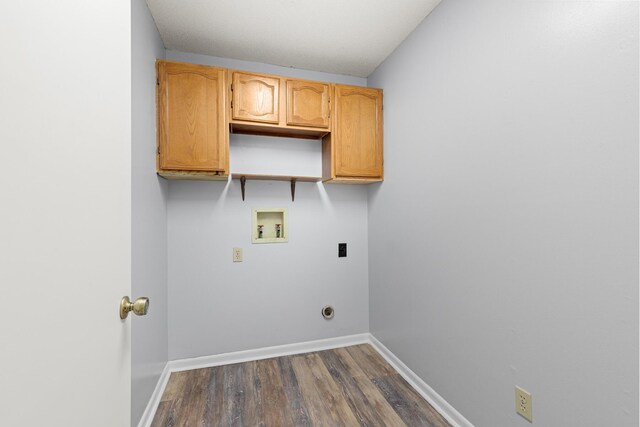 clothes washing area with cabinet space, hookup for a washing machine, baseboards, dark wood-type flooring, and hookup for an electric dryer
