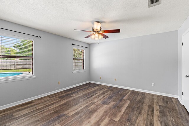 spare room featuring a ceiling fan, a textured ceiling, plenty of natural light, and wood finished floors