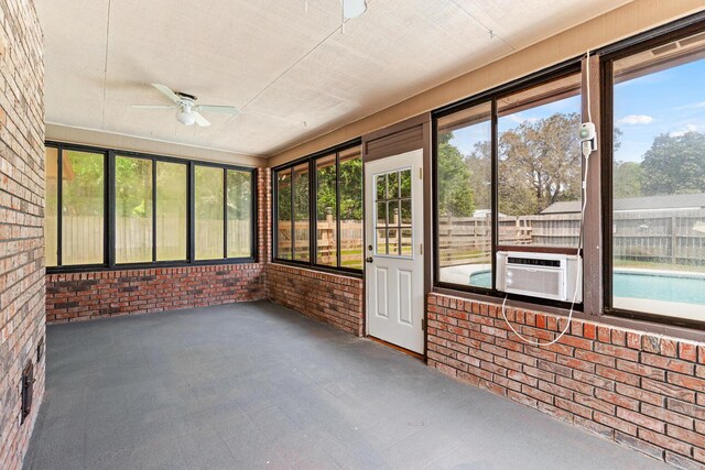 unfurnished sunroom featuring ceiling fan and cooling unit