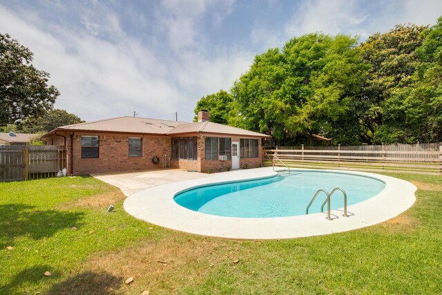 view of swimming pool featuring a lawn, a fenced in pool, and a fenced backyard